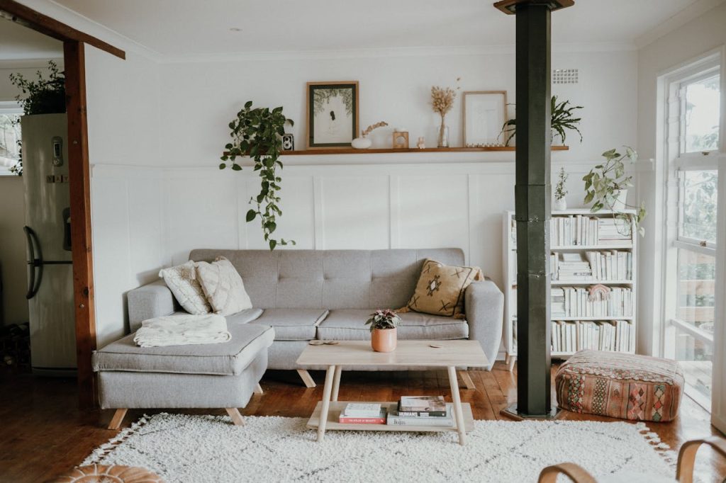 Bright and cozy living room with Scandinavian design and modern home decor, featuring a sofa and plants.